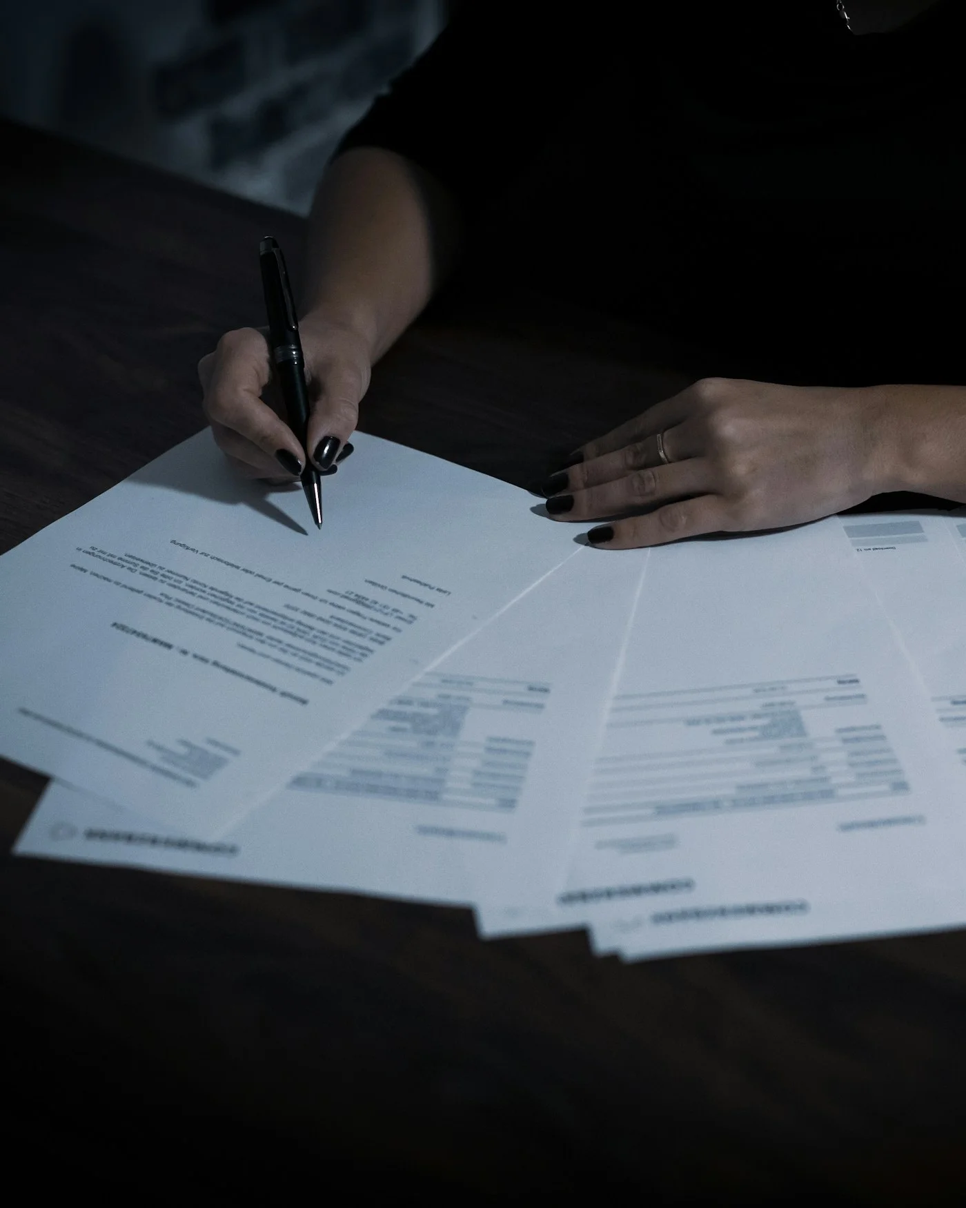 Procuradora firmando escritos judiciales sobre la mesa
